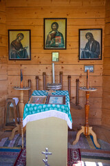 A wooden church with three paintings on the wall