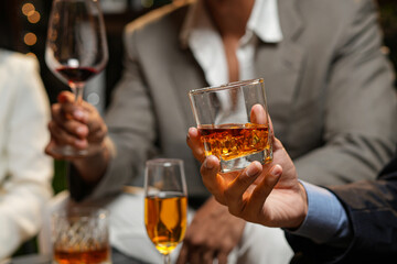 Closeup businessmen holding a glass of whiskey