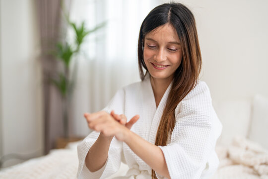 Woman applying lotion on arm for soft and hydrated skin, beauty and skincare at home, body care and moisturizing treatment cosmetics for glowing and healthy complexion, self-care and wellness