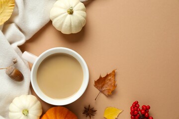 Beautiful autumn composition with cup of coffee, pumpkins and leaves on color background, top view, space for text