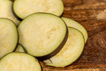 ripe purple eggplant sliced across with small seeds inside, ripe purple delicious eggplant sliced across the fruit on the kitchen table, close up