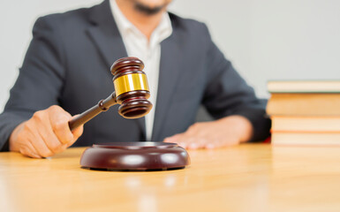 Male judge in a courtroom on wooden table. Counselor or Male lawyer working in office.