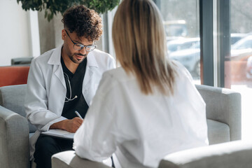 Consultation with doctor. Man and woman are indoors in modern building