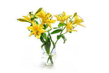 Yellow lilies as flower bouquet in a glass vase isolates with small shadow on a white background, copy space, selected focus