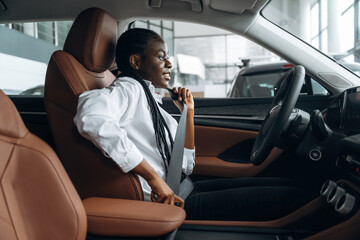 Safety first. Woman in white shirt is in the modern car