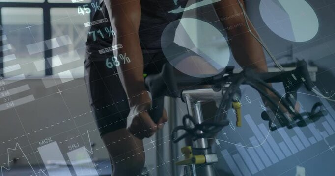 Male athlete gripping handlebars and pedaling in sports lab for testing data charts updating stats