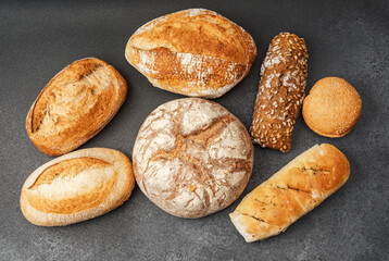 Variety of fresh artisan breads arranged on a dark surface