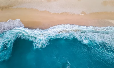  Aerial view down of bluish ocean smaller waves crashing onto the shore of a white sandy beach © venars.original