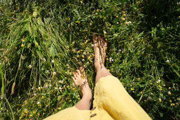 Woman in yellow dress enjoying a walk in the meadow with wildflowers