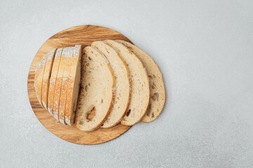 Slices of fresh bread arranged neatly on a wooden cutting board