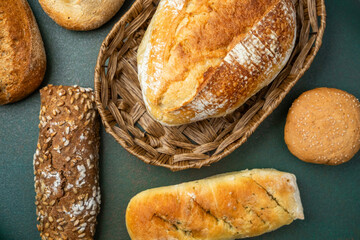 Freshly baked bread assortment displayed in a woven basket on a rustic surface