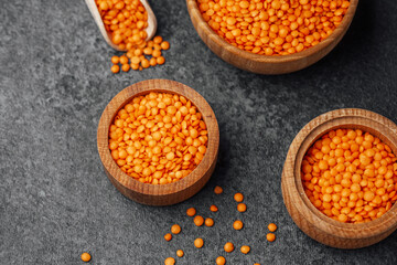 Diverse bowls of orange lentils arranged on a textured surface