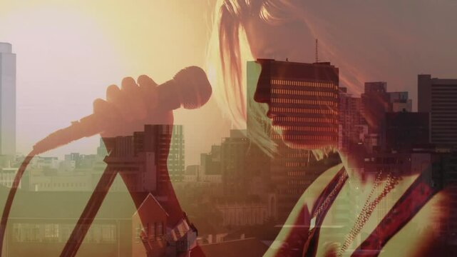 Teenage singer tightening mic clamp and clipping mic before singing music over sunset city skyline
