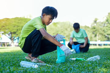 An Asian boy is a student in the Environmental Club and his friends help collect and sort waste plastic water bottles and glass bottles for recycling or reuse. In the concept of saving the world.