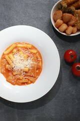 Korean Rose Tteokbokki, a creamy spicy rice cake dish topped with cheese, served with assorted...