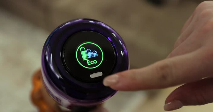 Woman hands and display control wireless portable vacuum cleaner. Technology concept. House cleaning.