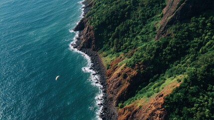 Obraz premium Aerial View of Dramatic Coastline with Vibrant Greenery and Water