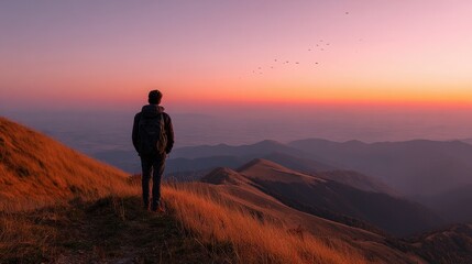 Fototapeta premium Scenic Sunset Over Mountains with Traveler in Silhouette View