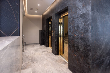 Modern hotel lobby with elevator and stairs