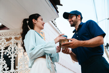 A woman picks up coffee, a burger and snacks from a drive-thru worker in front of her house during rush hour