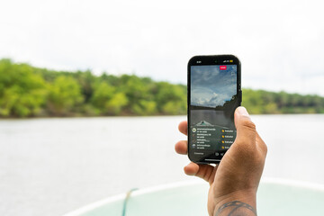 Videographer streaming a boat trip on a river in Tortuguero National Park, Costa Rica