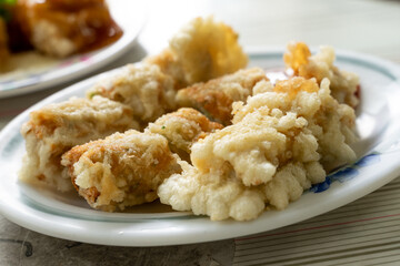 A crispy Taiwanese shrimp roll served hot and golden from the fryer. The roll is packed with minced shrimp, pork, and crunchy vegetables, all wrapped in tofu skin and deep-fried to perfection. Often