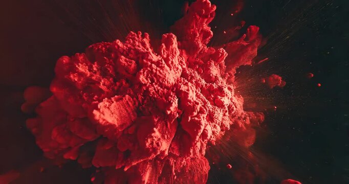 A vibrant red cloud explodes dynamically against a dark background, creating a visually stunning effect.