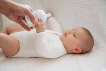 Giving bottle. Close up view of mother and little baby