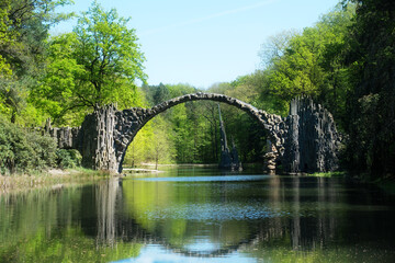 Scenic view of the iconic Rakotzbruecke (Devil’s Bridge) in Kromlau, Germany, reflected in the...