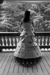 Creative fashion statement unfolds as a model stands in a handmade dress of newspapers overlooking...