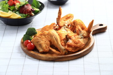 A popular Korean-style fried chicken dish featuring crispy wings and drumettes, served with fresh salad. Perfect as a meal or bar snack.