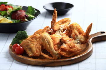A popular Korean-style fried chicken dish featuring crispy wings and drumettes, served with fresh salad. Perfect as a meal or bar snack.