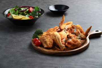 A popular Korean-style fried chicken dish featuring crispy wings and drumettes, served with fresh salad. Perfect as a meal or bar snack.