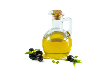 Extra virgin olive oil in a transparent jug and black olives with leaves.