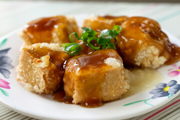 Taiwanese stinky tofu, deep-fried to a golden crisp on the outside while remaining soft inside, served with pickled cabbage and a spicy garlic sauce. This pungent yet beloved street food dish