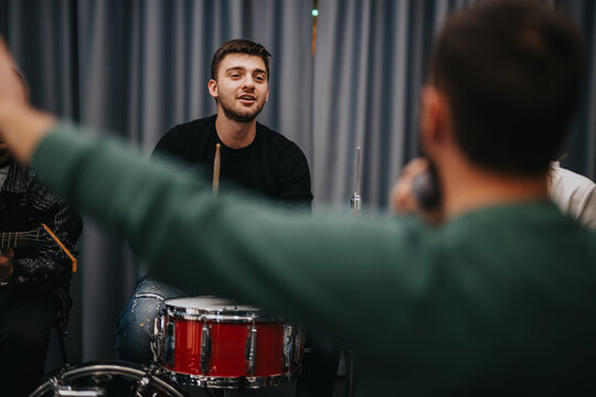 Group of musicians collaborating during studio rehearsal for a performance