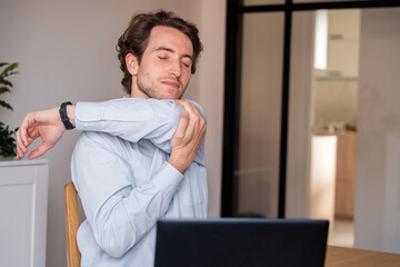 Man stretching arms at the office to relieve tension