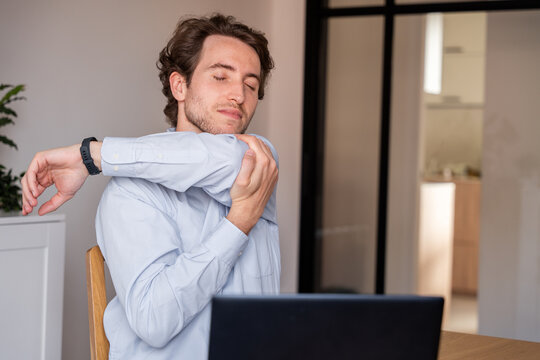 Man stretching arms at the office to relieve tension