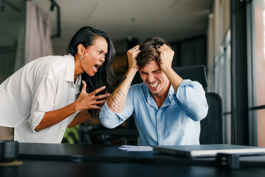 Fototapeta Boss shouting at frustrated worker, bullying and emotional abuse at work. Stressful work environment