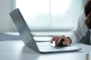 Professional typing on a laptop in office setting