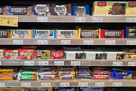 Penang, Malaysia &ndash; May 25, 2025: A neatly arranged selection of chocolate bars such as Hershey&rsquo;s Cookies 'n' Creme, KitKat varieties, and Lindt dark chocolate displayed on a retail shelf.