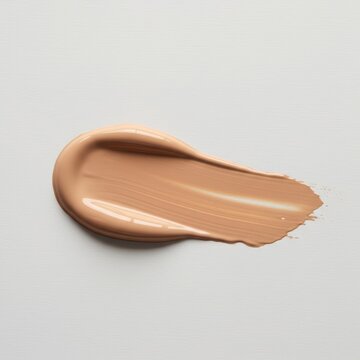 Close up of liquid foundation smear on white background. Makeup sample texture for beauty advertisement or cosmetic product tes