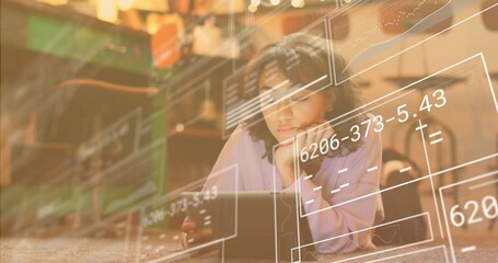 Woman lying on carpet tapping tablet and causing wireframe data overlays in technology demo
