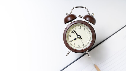 classic alarm clock and stacked books illustrating time management and education focus