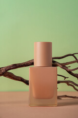 Cosmetic product in tube, bottle, lotion or serum and wood tree branch bark on green background. 