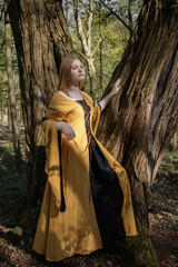 young woman in medieval dress in spring forest