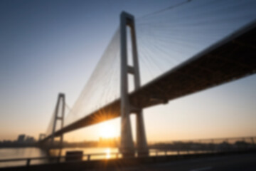 blurry photo of bridge in the afternoon showing beautiful sunset radiating from the corner of the bridge