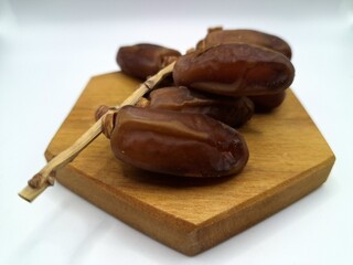 Date palm fruit on serving board. This is the edible, sweet fruit produced by the date palm tree