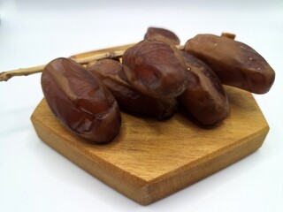 Date palm fruit on serving board. This is the edible, sweet fruit produced by the date palm tree