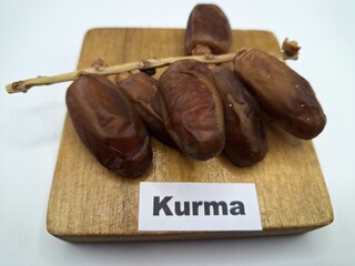 Date palm fruit on wooden serving board. Date palm fruits, or simply dates, are the oval-shaped, sweet, edible fruit of the date palm tree (Phoenix dactylifera)